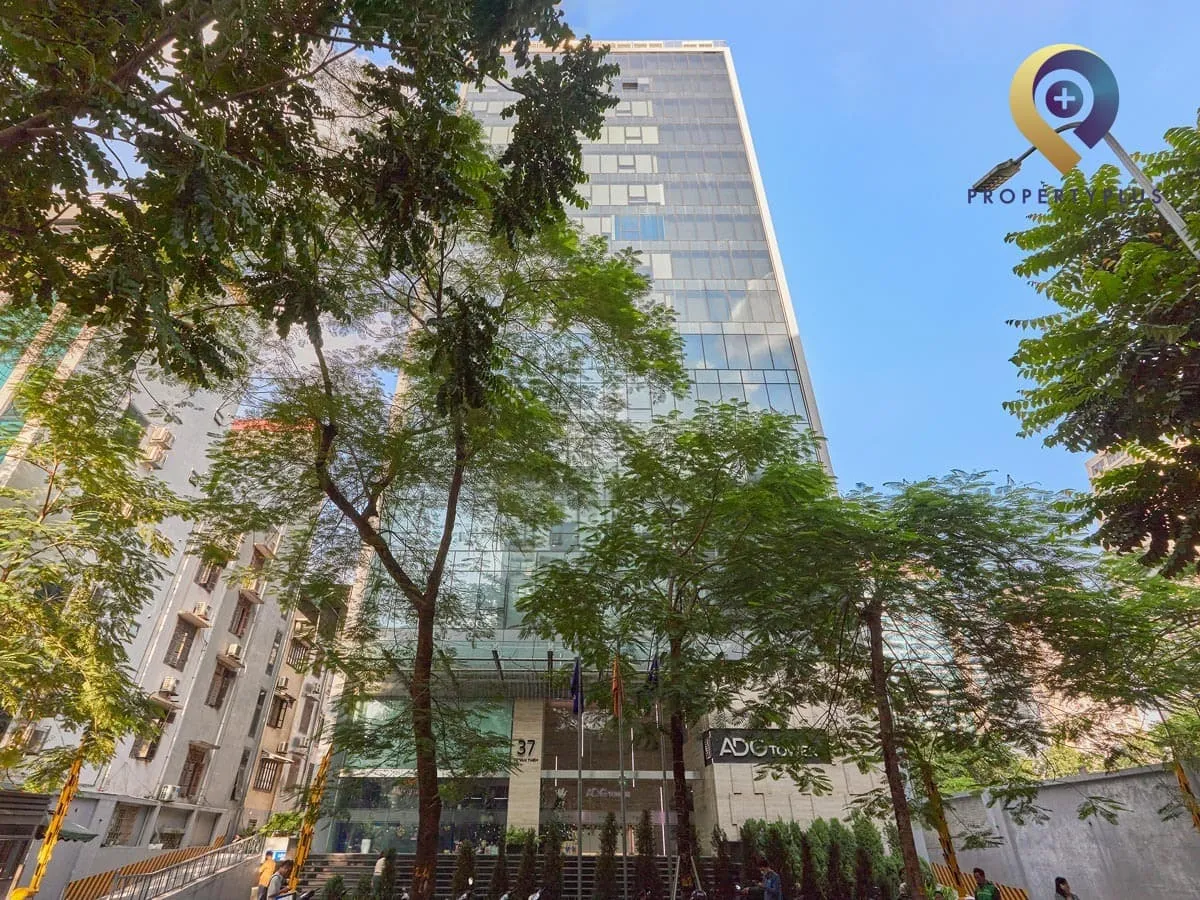Toàn cảnh tòa nhà ADG Tower nhìn từ phía trước, nổi bật giữa hàng cây xanh.